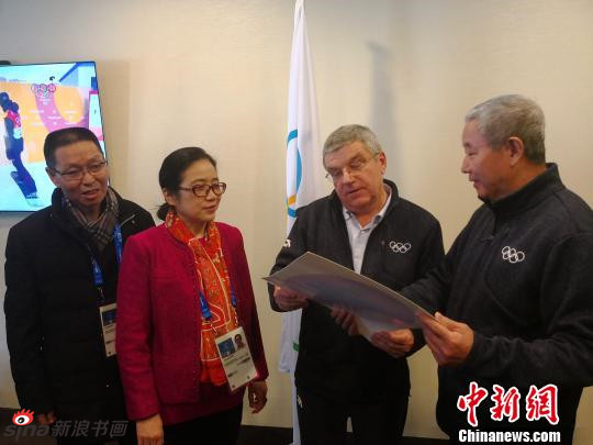 中国书法家协会副主席孙晓云（左二）向巴赫（右二）赠送了她书写的“福”字，国际奥委会副主席于再清（右一）向巴赫讲解“福”字的含义 “为奥运喝彩”项目组供图