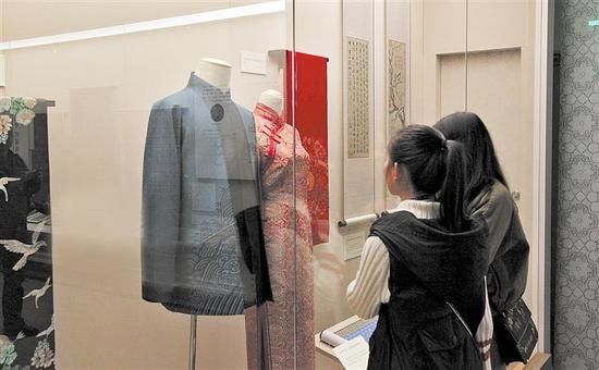 市民仔细欣赏“中国织锦文化展”上的展品 摄影 胡大田