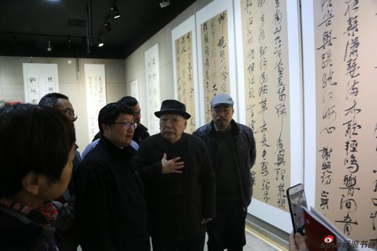 尉天池主席展览现场讲解参展的书法作品