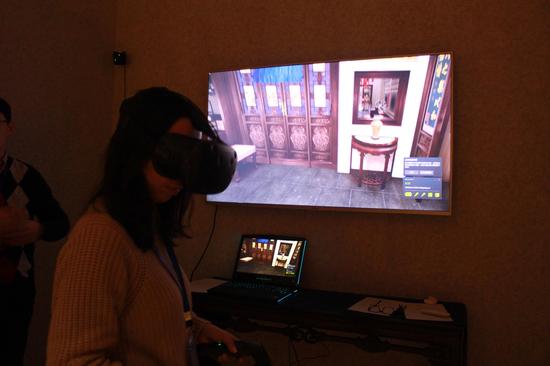 工作人员演示用VR技术体验养心殿后寝殿