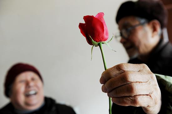 2011年2月14日，合肥，孙爷爷借助手中的玫瑰花向老伴孔令英表达自己心中的那份浓浓的情。