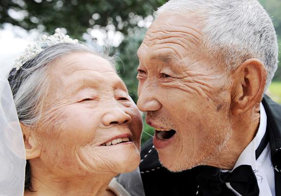 2011年10月2日,武义县茭道镇朱王村结婚73年夫妻相敬如宾的徐火生老人(右),看到老伴邹春莲(左)第一次穿上婚纱,开心地与老伴接吻。