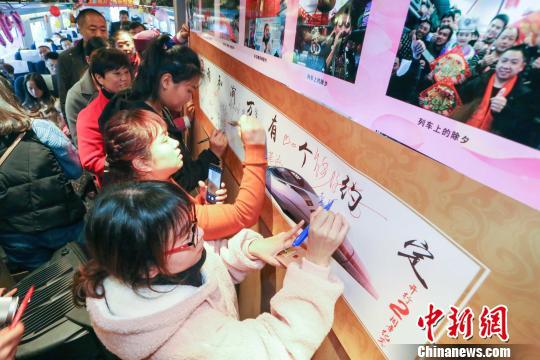 近日,重庆客运段举行渝万高铁运行两周年庆祝活动。图为乘车旅客在“我和渝万有个约定”签名墙上签名留念,并写下对渝万高铁的祝福 包亮 摄