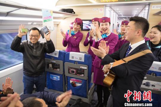 列车员与首发列车的旅客们一起联欢。 龚萱 摄