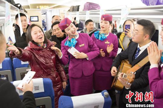 列车员与首发列车的旅客们一起联欢。 龚萱 摄