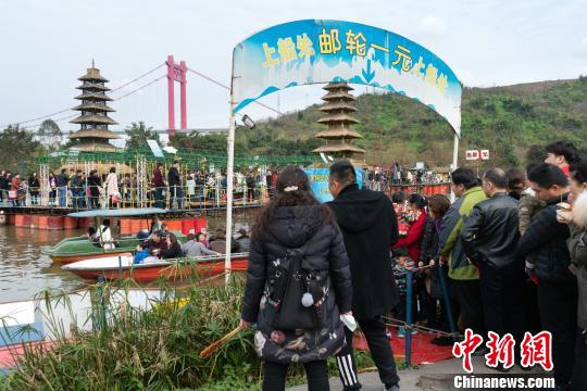 图为重庆洋人街景区,市民排队体验1元邮轮。 钟旖 摄