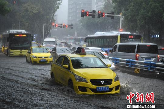 资料图为暴雨袭击重庆主城区,车辆通过积水路段。 陈超 摄