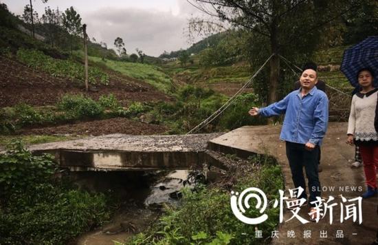 吕祖福的儿子在小桥前讲述自家多次建桥的经历。