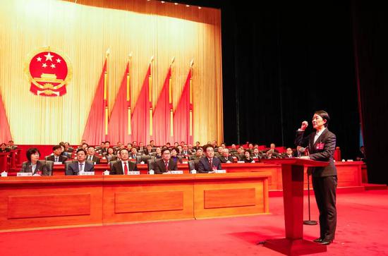 新当选的市监察委员会主任穆红玉在与会全体代表的见证下面向国旗宣誓。