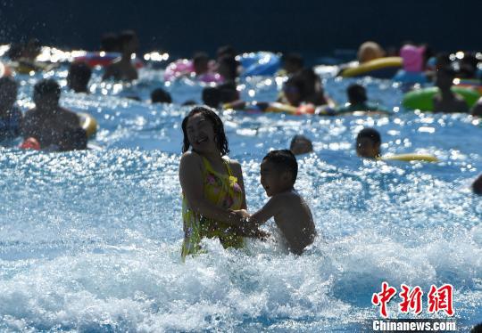 图为小孩与家长在水中嬉戏玩耍。 陈超 摄