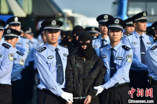 资料图为警方押解诈骗犯罪嫌疑人。警方供图