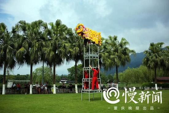 谢凤国和徒弟王华彪在四层八仙桌上表演重庆市非物质文化遗产项目“双桥狮舞”