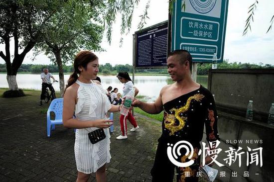 妻子杨玉婷为满头大汗的谢凤国送上冰冻矿泉水降温解渴