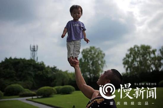 谢凤国单手将小孩托举,练习臂力