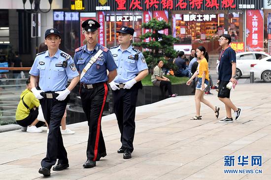 6月27日,中意警员在重庆解放碑进行联合巡逻。新华网 李相博 摄