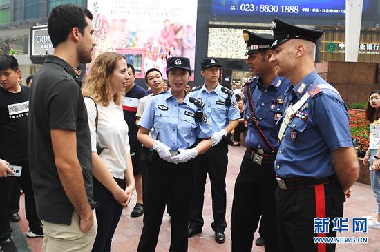 6月27日,中意警员在重庆解放碑为外国游客提供帮助。新华网 李相博 摄