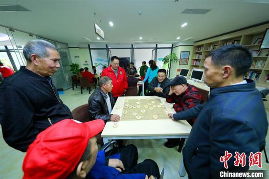 图为老年人在公共设施内下棋。 资料图