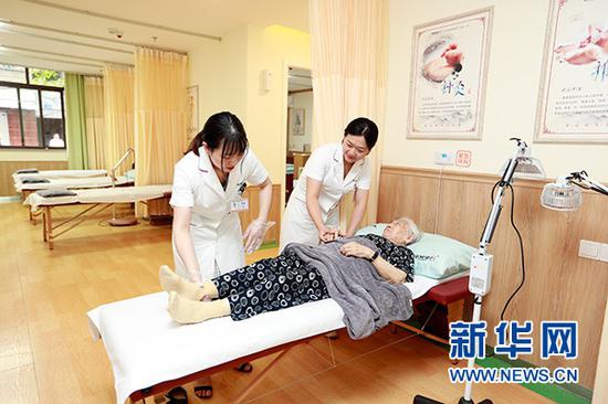 图为重庆市渝北区龙山街道,社区老人在养老服务中心进行康复理疗。新华网发(重庆市民政局供图)