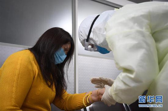 2月17日,新冠肺炎康复患者舒某(左)在做捐献血浆前的准备工作。新华社记者 唐奕 摄