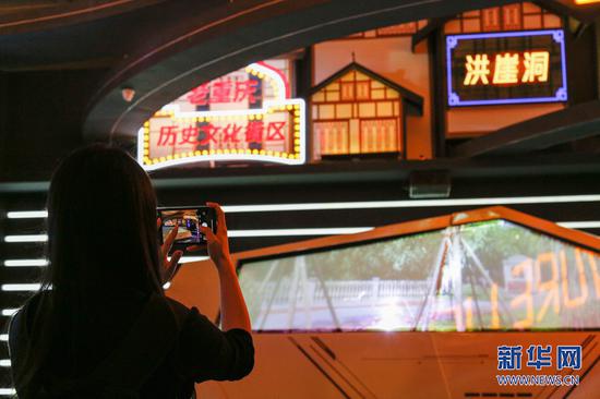 一位参观者正在馆内的重庆历史文化街区前留影。新华网发 耿骏宇 摄