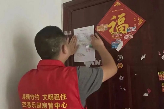 区住房城乡建委上门张贴违规违约查处解约通知书。杨荟琳 摄