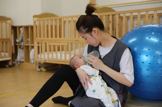 育儿老师给孩子喂母乳。韦围 摄