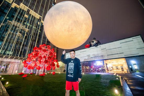 图为艺术家黄玉龙与月亮装置合影。重庆IFS供图
