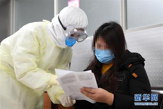 2月17日,新冠肺炎康复患者舒某(右)在做捐献血浆前的准备工作。新华社记者 唐奕 摄