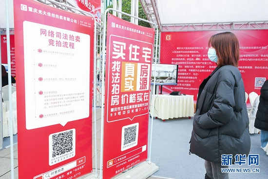 12月17日,重庆市第一中级人民法院、重庆市江北区人民法院在观音桥商圈开展网络司法拍卖宣传专场活动。图为一位市民在了解司法拍卖相关知识。新华网 发