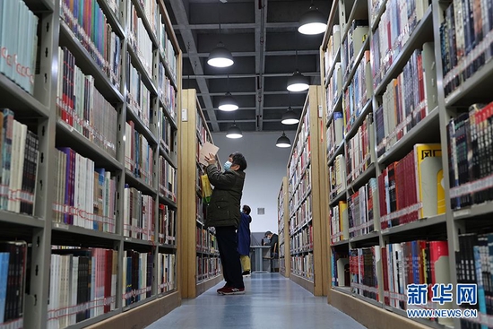 图为读者在书架上寻找自己想看的图书。新华网发(孙凯芳 摄)