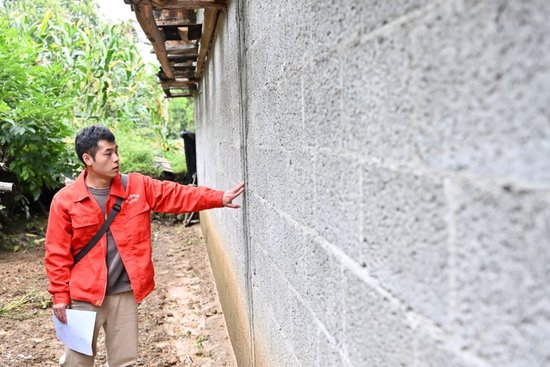 9月25日,地质工程师在重庆市巫山县笃坪乡腰栈村查看受损房屋情况。新华社记者王全超摄