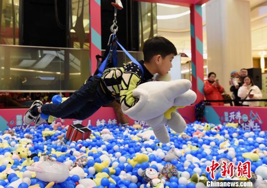图为小朋友体验真人抓娃娃活动。 周毅 摄