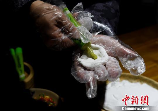 图为工作人员为食客包芥末汤圆煮火锅。 周毅 摄