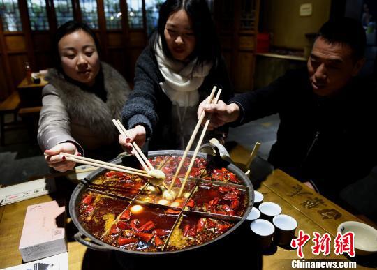 图为食客在麻辣火锅里煮汤圆庆元宵节。 周毅 摄