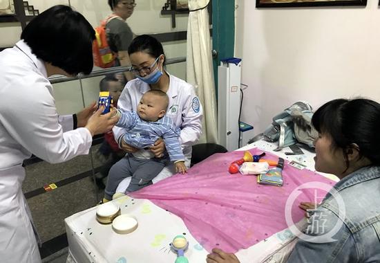 △一个医生给小孩做按摩治疗,另一个医生拿玩具逗孩子玩,以免哭闹。