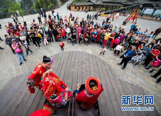 在重庆市武隆区仙女山国家级旅游度假区天坑寨子景区内,演员们在为游客表演当地特色传统婚嫁礼俗(2017年4月15日摄)。新华社记者 刘潺 摄