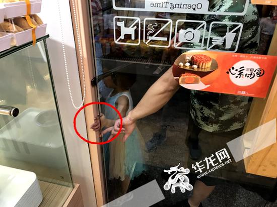 小女孩手被门缝卡主,取不出来。通讯员 成雪 摄