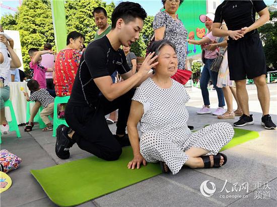 活动现场,健身教练教市民朋友科学运动的方法。