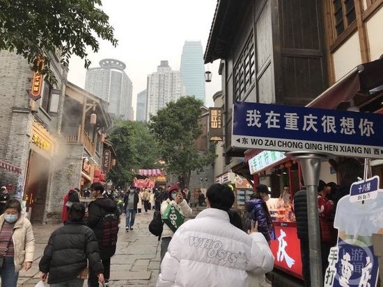 △1月2日下午,不少游客冒雨到十八梯打卡。