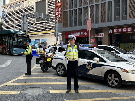 “五一”当天正在执勤的重庆市渝中区公安分局交巡警支队朝天门大队巡长何光君(右)和辅警郑元果(左)。新华社记者李晓婷 摄