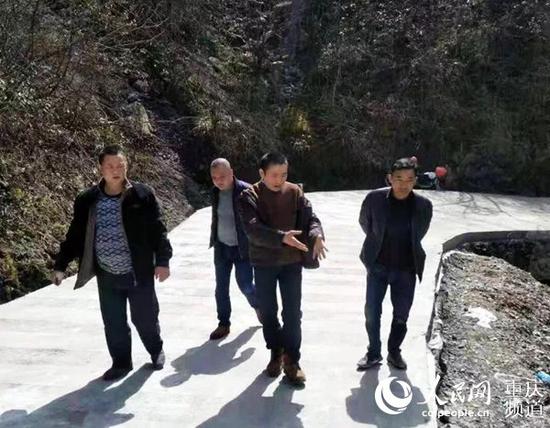 周康云(中)生前扶贫调研。开州区委宣传部供图