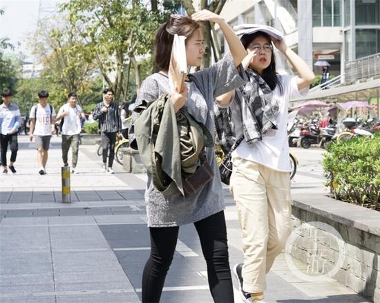 △大学城,学生们用手和书遮挡烈日。