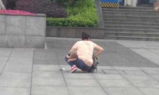 重庆一女子带着小孩当街大便 留下一地"黄金"