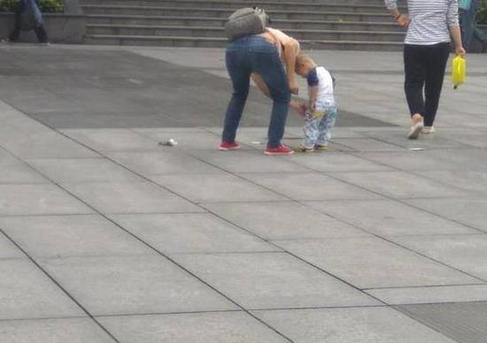 重庆一女子带着小孩当街大便 留下一地"黄金"