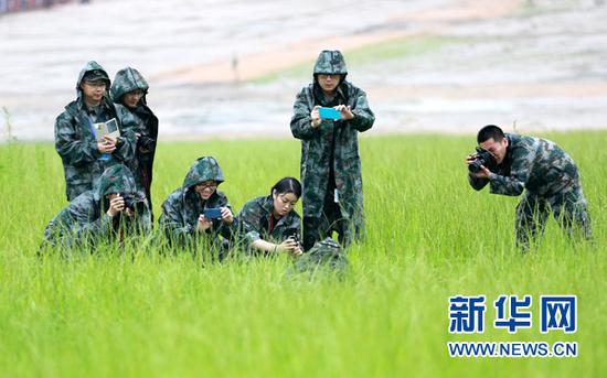 图为网络媒体国防行记者编辑冒雨拍摄特战旅的战士。(中国经济网裴小阁 摄)