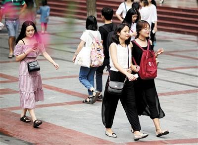 天气凉爽,市民在三峡广场悠闲逛街。