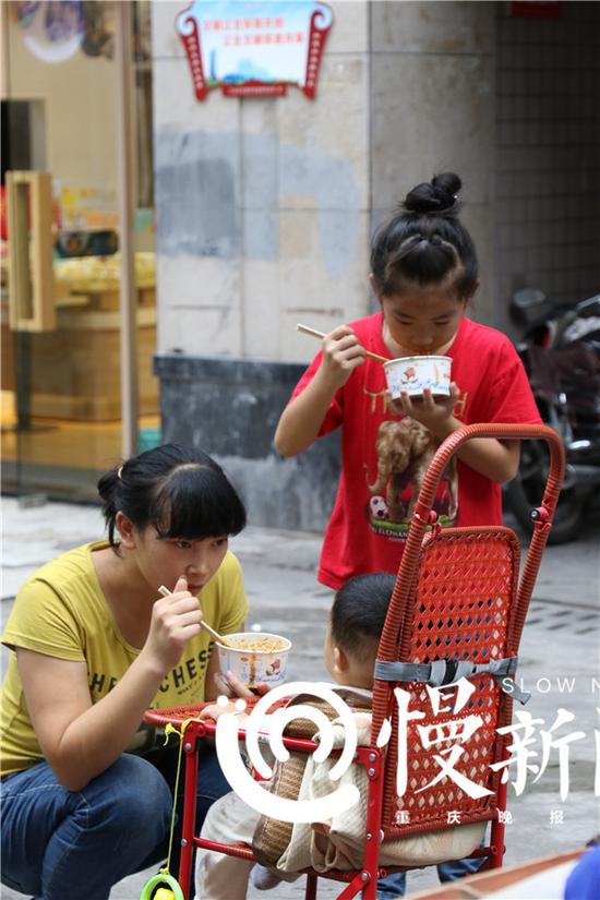 一位妈妈带孩子一起吃凉面