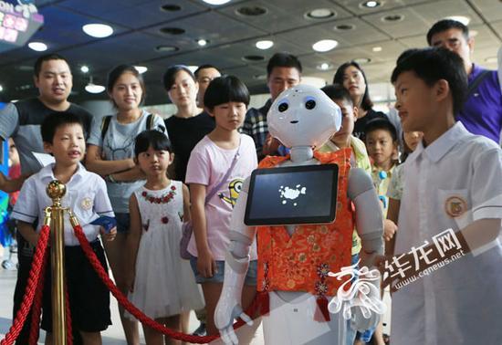 孩子们与会说话的智能机器人互动。记者 李文科 摄