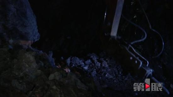 晚上7点多,记者赶到了垮塌现场看到,巨石横亘路中间,车辆和行人无法通行。装载机和挖掘机正在加紧作业。