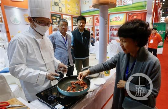 bcbd9ef2b8b5ce090b5875f1fe4d4238.jpg △市民在展销会现场品尝美食。